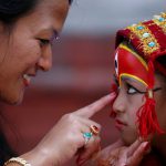 A woman smiles as she speaks to a young girl dressed as the living goddess Kumari during the Kumari Puja festival in Kathmandu.