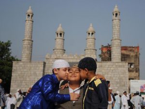 Children exchange greetings after Eid prayers on the Eid al-Adha occasion at the prayer ground in Jammu