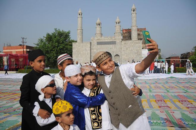 Children take a selfie after Eid prayers on the Eid al-Adha occasion at the prayer ground in Jammu