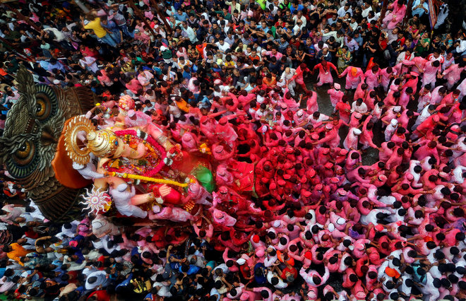 Devotees carry the idol of Hindu god Ganesh, the deity of prosperity, through a street on the last day of the Ganesh Chaturthi festival in Mumbai, on September 15. Hindu devotees bring home idols of Lord Ganesha in order to invoke his blessings during the eleven-day long festival which culminates with the immersion of the idols in different water bodies.