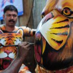 Indian artists paint performers with body-paint depicting tigers as they prepare to take part in the Pulikali, or Tiger Dance, in Thrissur on September 17, 2016. The folk-art event is held every year in the town during the Onam festival.