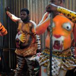 Indian performers wearing body-paint depicting tigers wait for the artwork to dry as they prepare to take part in the Pulikali, or Tiger Dance, in Thrissur on September 17, 2016. The folk-art event is held every year in the town during the Onam festival.
