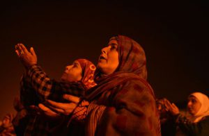 Kashmiri Muslim women react as a priest displays a relic believed to be a hair from the beard of Prophet Mohammad during Eid-e-Milad, the birth anniversary of the Prophet, at the Hazratbal Shrine in Srinagar on December 12, 2016.