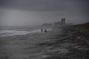 People bike on the beach ahead of hurricane Matthew in Atlantic Beach, Florida, on October 5, 2016.