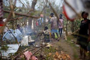 People cook their meal next to fallen trees after Hurricane Matthew passes Jeremie, Haiti, on October 5, 2016.