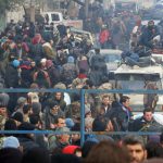 Rebel fighters and civilians gather as they wait to be evacuated from a rebel-held sector of eastern Aleppo, Syria, on December 16, 2016.