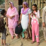 Villagers from the India-Pakistan border area wait for the bus as they evacuate from the border village of Neshta, about 35 kms from Amritsar on September 29.
