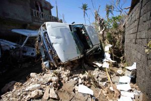 A car stands on its side after being blown away by winds brought by Hurricane Matthew in Jeremie, Haiti, on October 7, 2016. People across southwest Haiti were digging through the wreckage of their homes Friday, salvaging what they could of their meager possessions after Matthew killed hundreds of people in the impoverished country.