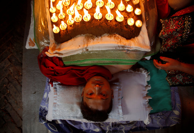 A devotee offers oil lamps on top of his body while offering prayers during ‘Dashain’, a Hindu religious festival in Bhaktapur, Nepal, on October 11, 2016.