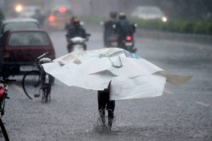 A man walks on a waterlogged road as cyclone Vardah makes landfall near Chennai coast on December 12, 2016