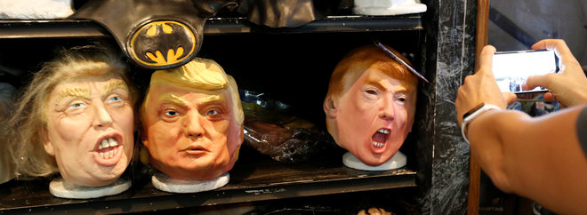 A person takes a photo of masks depicting Republican presidential nominee Donald Trump at Hollywood Toys & Costumes in Los Angeles, California US, on October 26, 2016.
