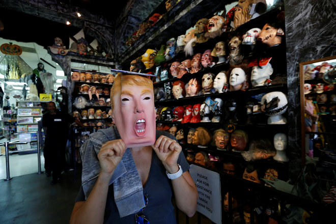 A person tries on a mask depicting Republican presidential nominee Donald Trump at Hollywood Toys & Costumes in Los Angeles, California, US, October 26, 2016.