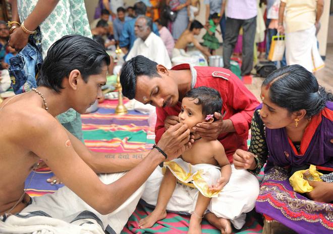 A priest performs ‘Vidhyarambam’ on Dushhera-Vijaya Dashami at a temple in Coimbatore on October 11, 2016.