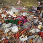 An Indian boy looks for re-usable materials amongst the remains of idols and worship items on the banks of the River Yamuna during the Durga Puja festival in New Delhi on October 11, 2016.