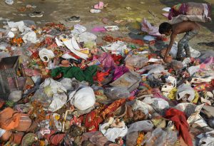 An Indian boy looks for re-usable materials amongst the remains of idols and worship items on the banks of the River Yamuna during the Durga Puja festival in New Delhi on October 11, 2016.