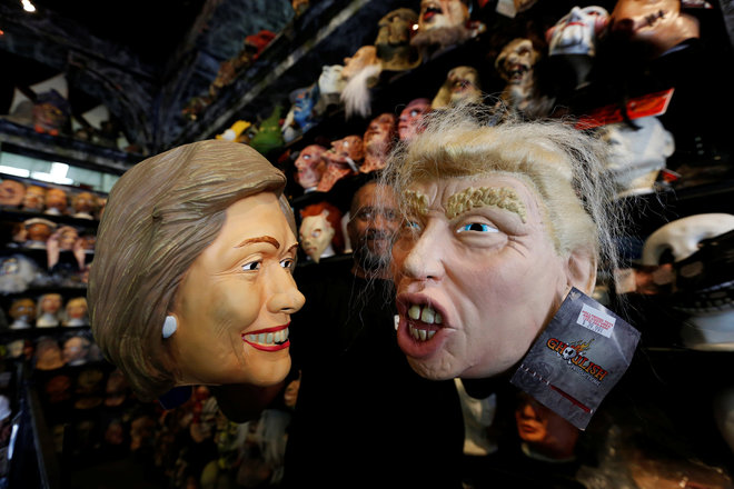 An employee holds up masks depicting Democratic presidential nominee Hillary Clinton and Republican presidential nominee Donald Trump at Hollywood Toys & Costumes in Los Angeles, California, US, on October 26, 2016.