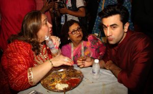 Bollywood actor Ranbir Kapoor (R) has Bhog — sacred food — during celebrations at the North Bombay Sarbojanin Durga Puja in Mumbai on October 9, 2016.