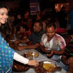 Bollywood actress Hrishitaa Bhatt (L) gestures at the serving of Bhog — sacred food — during celebrations at the North Bombay Sarbojanin Durga Puja in Mumbai on October 9, 2016.