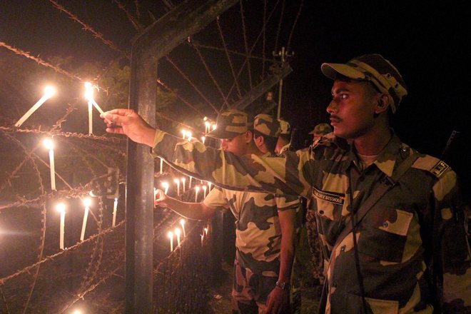 Border Security Force (BSF) troopers light candles along the India-Bangladesh border as they celebrate Diwali in Shivrampur near Balurghat in West Bengal’s South Dinajpur district of West Bengal on October 28, 2016.