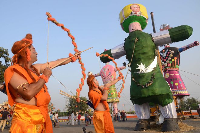 Hindus devotees dressed as deities Lord Rama and Laxman aim a bow and arrow towards an effigy bearing the image of Pakistan’s Prime Minister Nawaz Sharif in the likeness of Ravana the Hindu demon king, as they take a part in a religious procession in Amritsar on October 11, 2016, on the occasion of the Hindu festival of Dussehra.