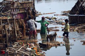 Indian scavengers look for coins and re-usable items amongst the religious offerings and wooden frames of idols of goddess Durga that are piled up in the Yamuna river in New Delhi on October 12, 2016, following the Durga Puja festival.
