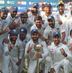 Indian team players hold the ICC best test team trophy after winning the Test series against New Zealand at the Holkar Cricket Stadium in Indore on October 11, 2016.