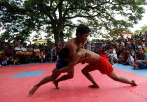 Men wrestle during the Pchum Ben festival, in Vihear Sour village in Kandal province, Cambodia, on October 1, 2016.