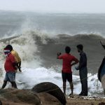 People watch as waves lash Marina Beach after Cyclone Vardah makes landfall on the coast of the Bay of Bengal in Chennai on December 12, 2016
