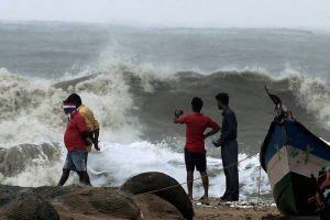 People watch as waves lash Marina Beach after Cyclone Vardah makes landfall on the coast of the Bay of Bengal in Chennai on December 12, 2016