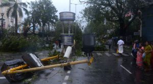 Residents stand near debris on a street in Chennai as Cyclone Vardah approaches the Indian coast on December 12, 2016