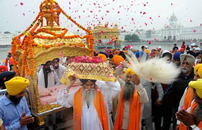 Sikh devotees take part in a procession at the Golden Temple on 548th birth anniversary of Guru Nanak Dev in Amritsar