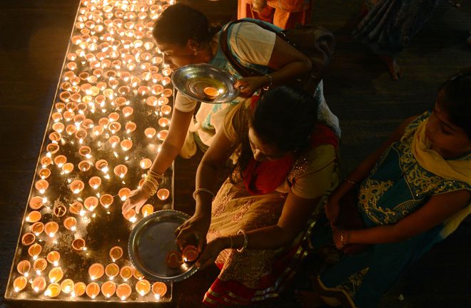 Sri Lankan Hindu devotees light oil lamps during Diwali, the Festival of Lights, at a temple in Colombo on October 29, 2016.