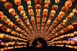 This photo taken on October 24, 2016, shows a visitor posing for photos during a pumpkin lantern show in front of a shopping mall to mark the Halloween in Shenyang, northeast China’s Liaoning province.
