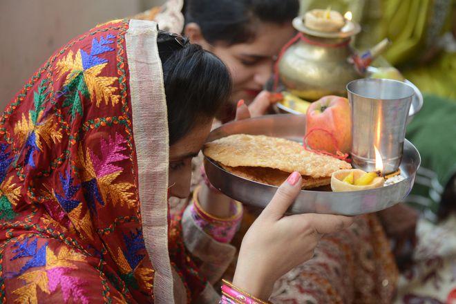 Women gather for a prayer event during the Karva Chauth festival at a temple in Amritsar on October 19, 2016.