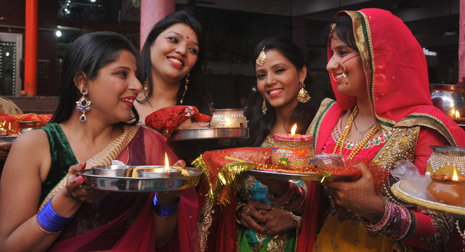 Women perform rituals during the Karwa Chauth festival at a temple in Mohali OCtober 19, 2016.