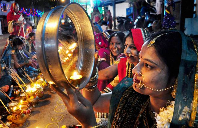 Women perform rituals during the Karwa Chauth festival at a temple in Nagpur on October 19, 2016.