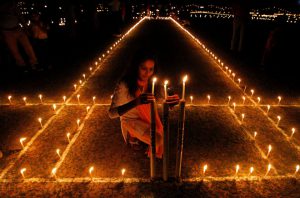 A girl lights candles inside a cricket stadium on the eve of Diwali, in Allahabad.