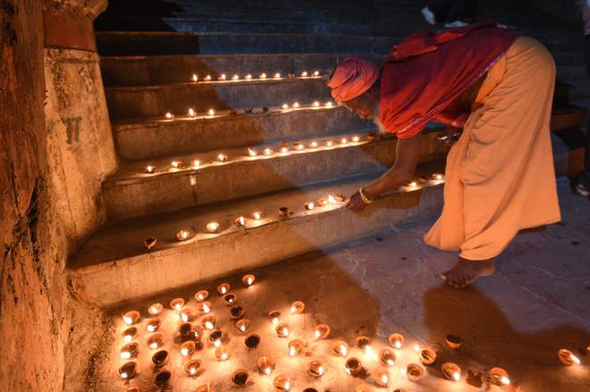 A sadhu lights diyas on the banks of the Ganges river during celebrations of Diwali, the Festival of Lights, in Rishikesh.