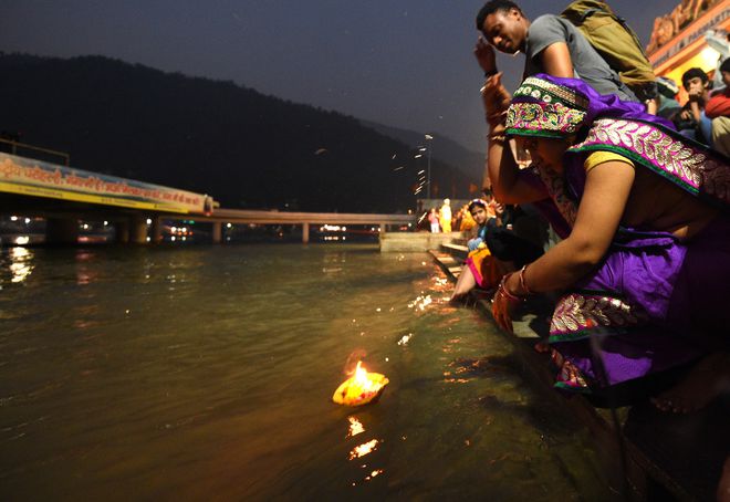 A woman prays as she sets a burning candle afloat in the Ganges during celebrations of Diwali, the Festival of Lights, in Rishikesh.