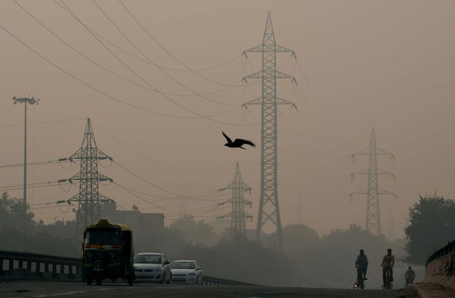 Commuters make their way through smog in New Delhi on October 31, the day after the Diwali festival.