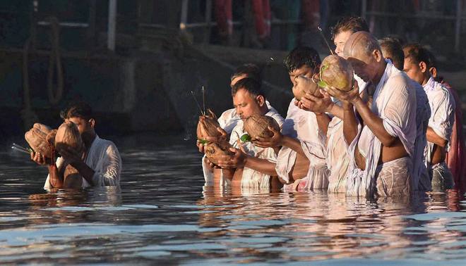 Devotees offering prayers to Sun God on the occasion of Chhath Puja at the banks of river Brahmaputra in Guwahati