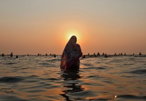 Devotees worship the Sun god in the waters of the Arabian Sea during Chhath Puja in Mumbai