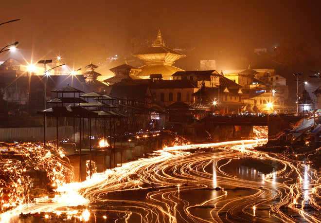 Oil lamps offered by devotees illuminate the Bagmati River flowing through the premises of the Pashupatinath Temple during the Bala Chaturdashi festival in Kathmandu, Nepal, on November 28, 2016.