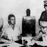 This file photo taken on July 26, 1953, shows Fidel Castro (2ndL) giving his deposition to Colonel Chabiano, military chief of the Moncada Garrison, at the Vivac in Santiago de Cuba, after the attack on the Moncada garrison house by the group led by Castro.