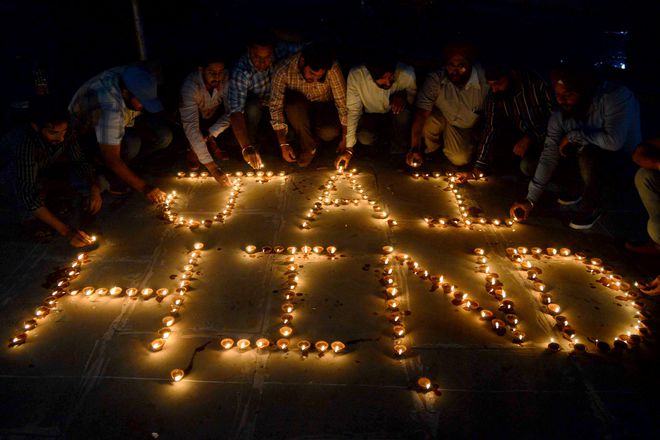 Volunteers light diyas in the shape of Jai Hind!