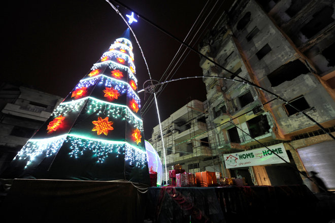 A Christmas tree lights near damaged buildings during Christmas eve in al-Hamidiyah neighbourhood in the old city of Homs, Syria December 24, 2016.