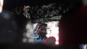 A Pakistani Muslim tries on a prayer cap at a roadside stall in Karachi.