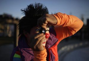 A Salvadorean clown plays with a toy camera as he takes part in the National Clown Day celebrations at Beethoven Square in San Salvador, December 3, 2014.