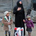 A Syrian woman, fleeing violence in the restive Bustan al-Qasr neighbourhood, reacts as she stands with her children in Aleppo’s Fardos neighbourhood on December 13, 2016, after regime troops retook the area from rebel fighters.