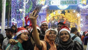 A group of young people take a selfie during Christmas Eve celebration before mid-night mass prayer at Park Street in Kolkata